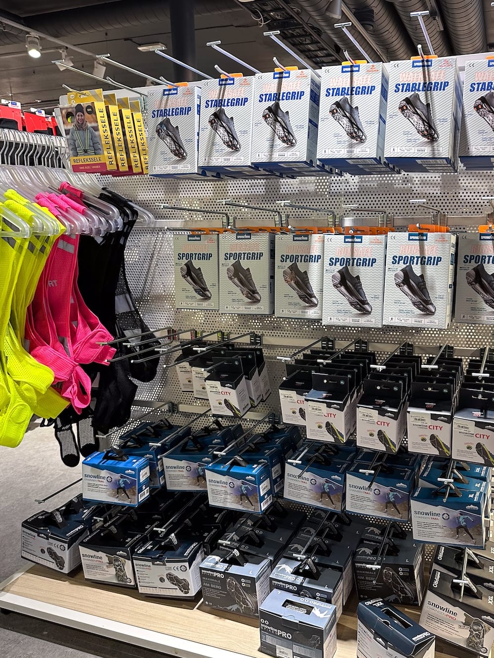 a display of ice spikes, crampons, and safety vests in tromso