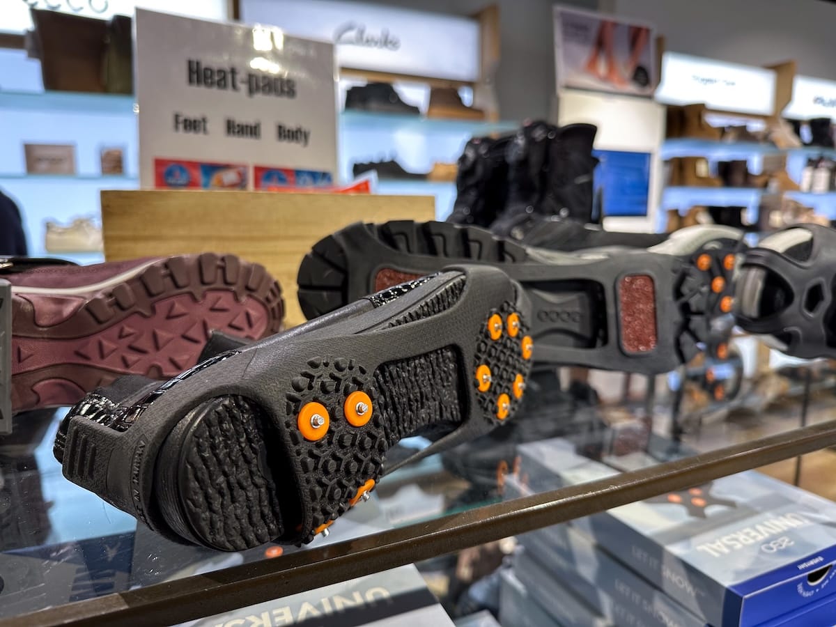 Ice spikes (or crampons) in tromsø norway. a shoe with spikes on its sole on top of a glass cabinet