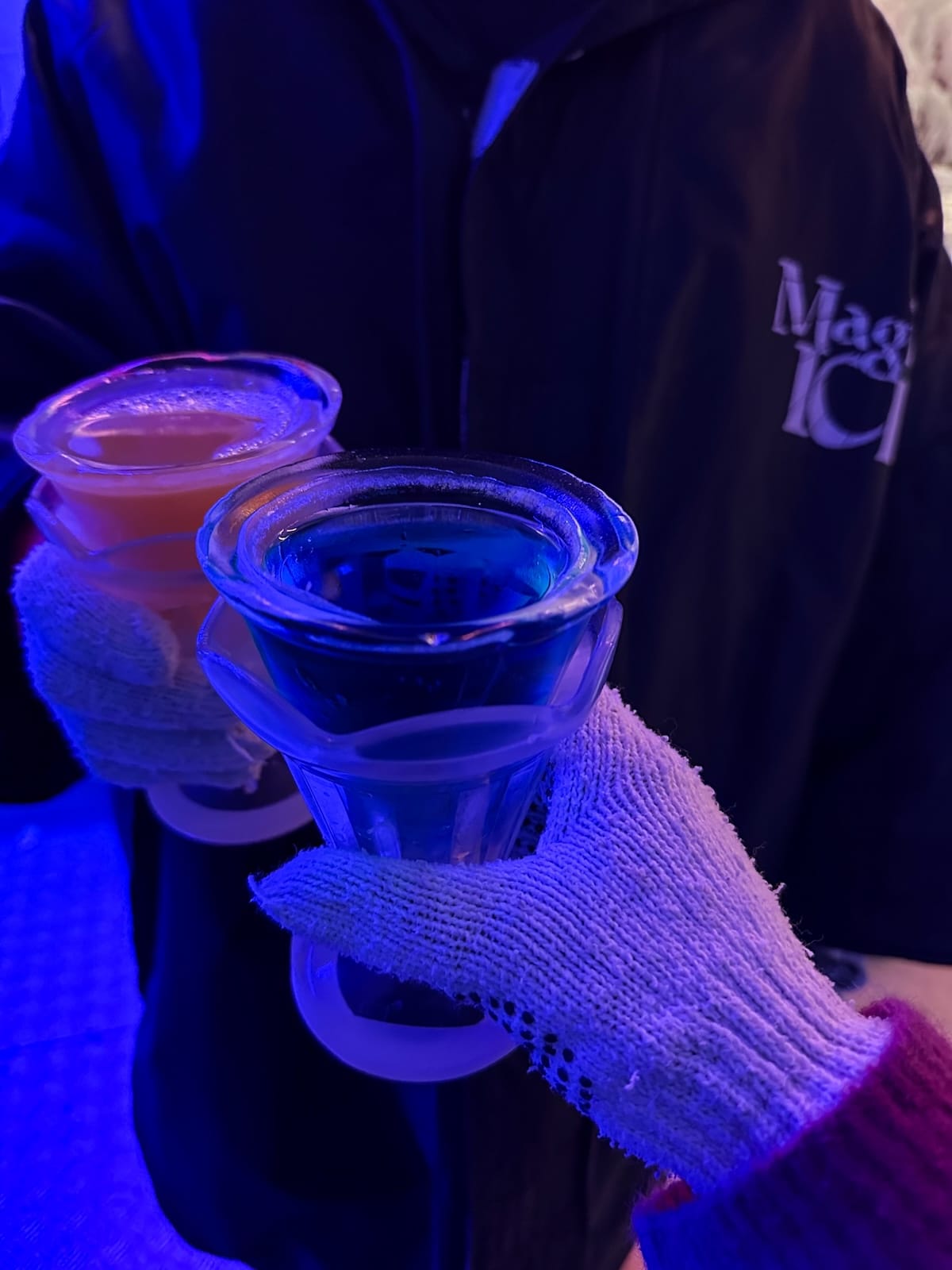 two hands putting two drinks together in an ice bar